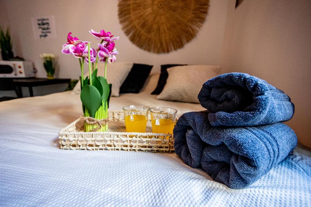 a bed with towels and two glasses of orange juice and flowers at Haran in Jerusalem