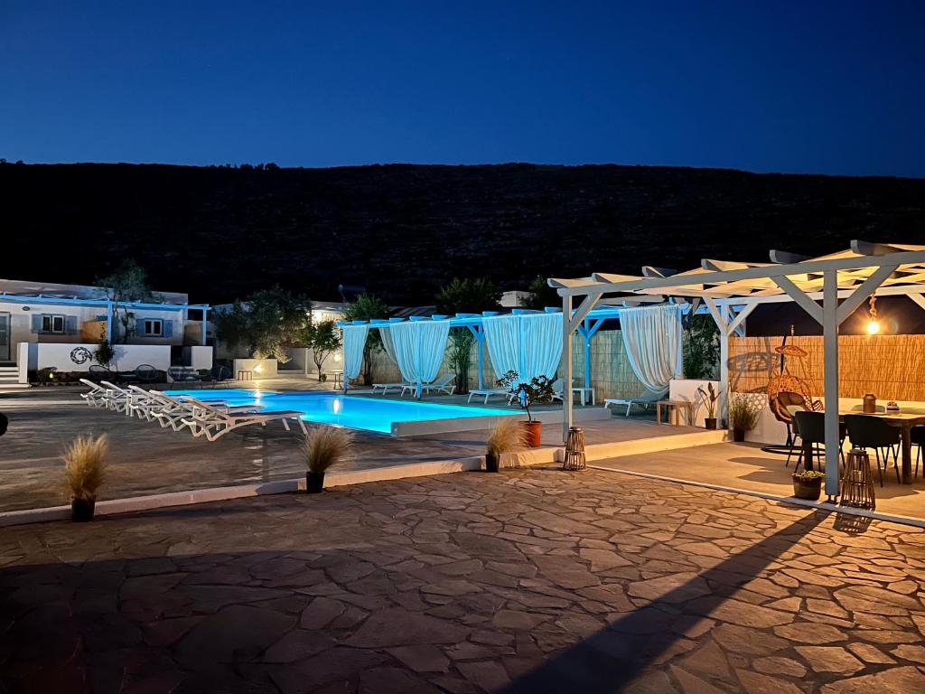 a large swimming pool with a table and a patio at Family Villages Santorini in Vlychada Beach