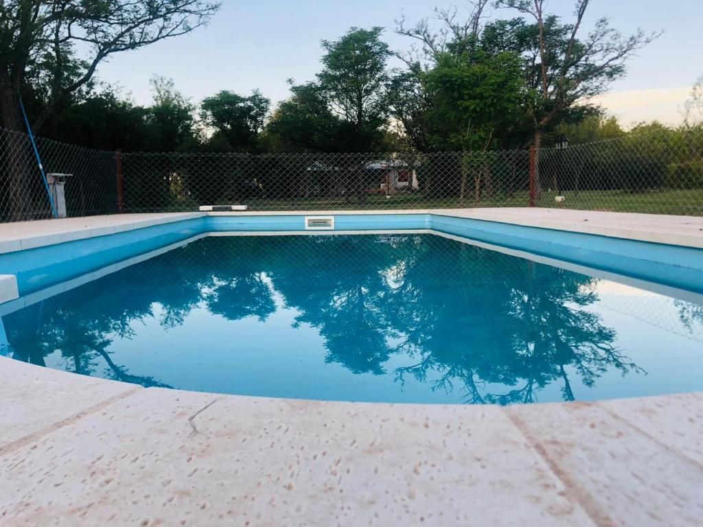 una piscina de agua azul en un patio en Casas de Campo Famailla en Nono