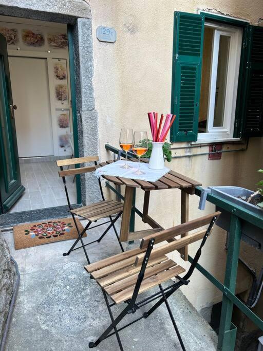 una mesa con 2 sillas y copas de vino en el patio en Loft con spazio esterno Lissa, en Riomaggiore