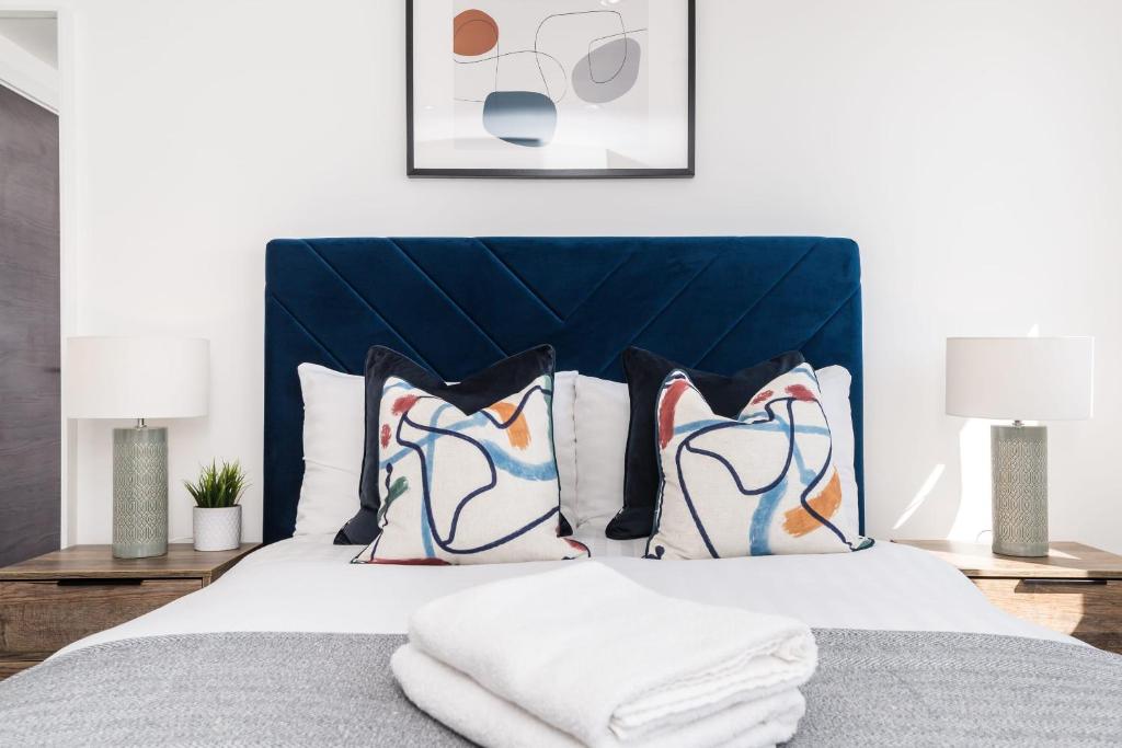 a bedroom with a bed with a blue headboard and pillows at Host & Stay - The Baltic Penthouse 3 in Liverpool