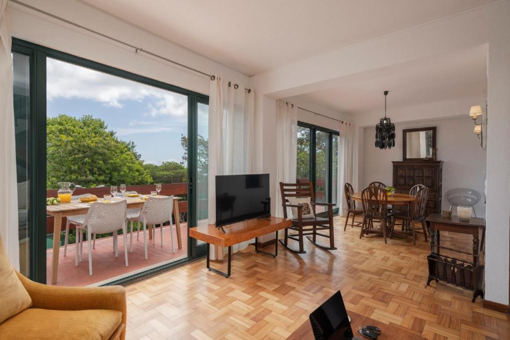 a living room with a television and a dining room at Matur I by An Island Apart in Água de Pena