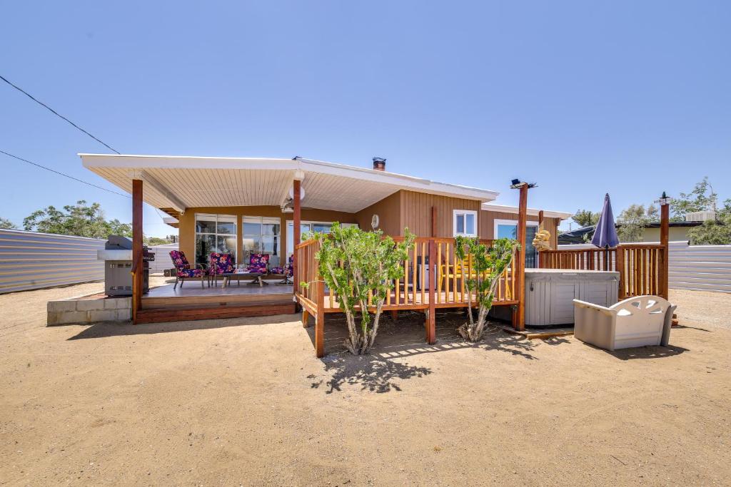a house with a porch and a deck with a patio at Charming Home with Hot Tub about 5 Mi to Joshua Tree! in Joshua Tree