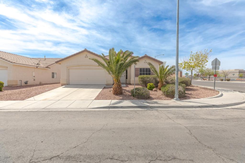a house with palm trees in front of a street at Beautiful Spacious Single Story Vegas Home in Las Vegas
