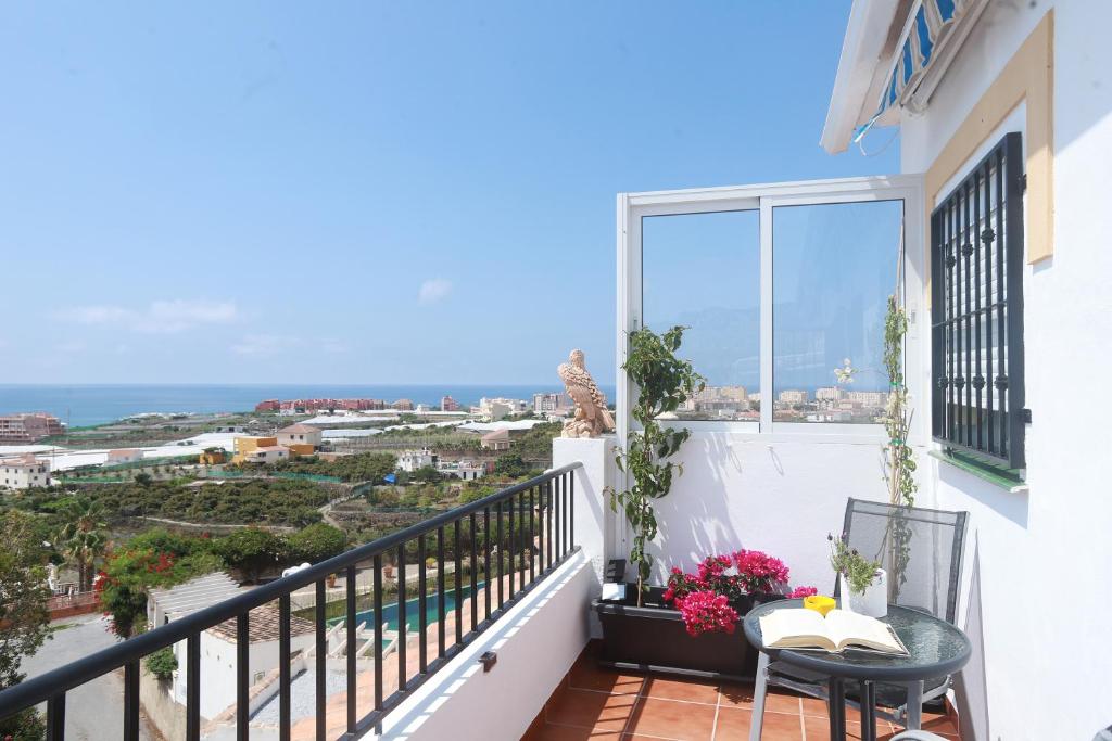 een balkon met een tafel en uitzicht op de oceaan bij TU CASA CERCA DEL MAR in Torrox