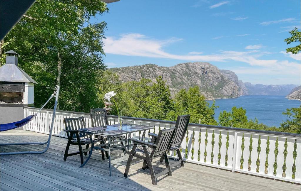 a table and chairs on a deck with a view of the water at Beautiful Home In Forsand With Wifi And 2 Bedrooms in Forsand