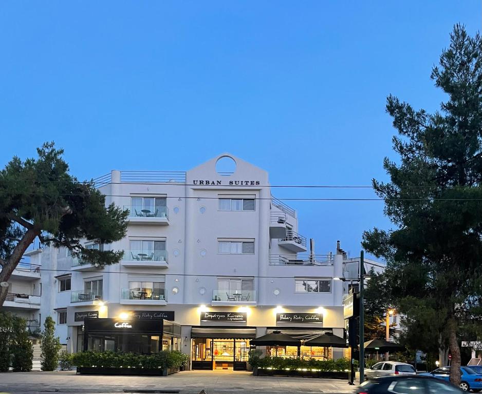 - un grand bâtiment blanc avec un panneau dans l'établissement URBAN SUITES ATHENS, à Athènes