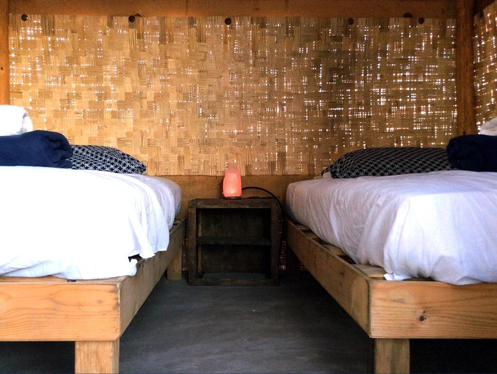 a room with two beds and a table with a night stand at Sunset Paradise - Todos Santos in Todos Santos