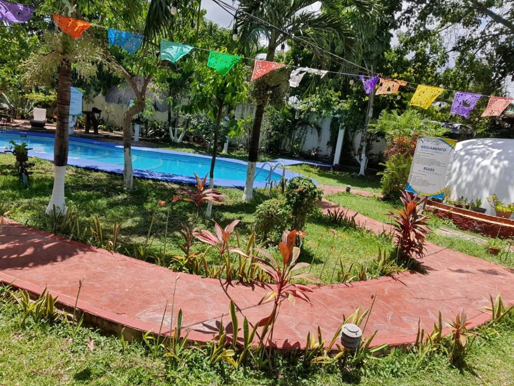 Un jardín con piscina y banderas. en Cabañas Colibrí, en Bacalar