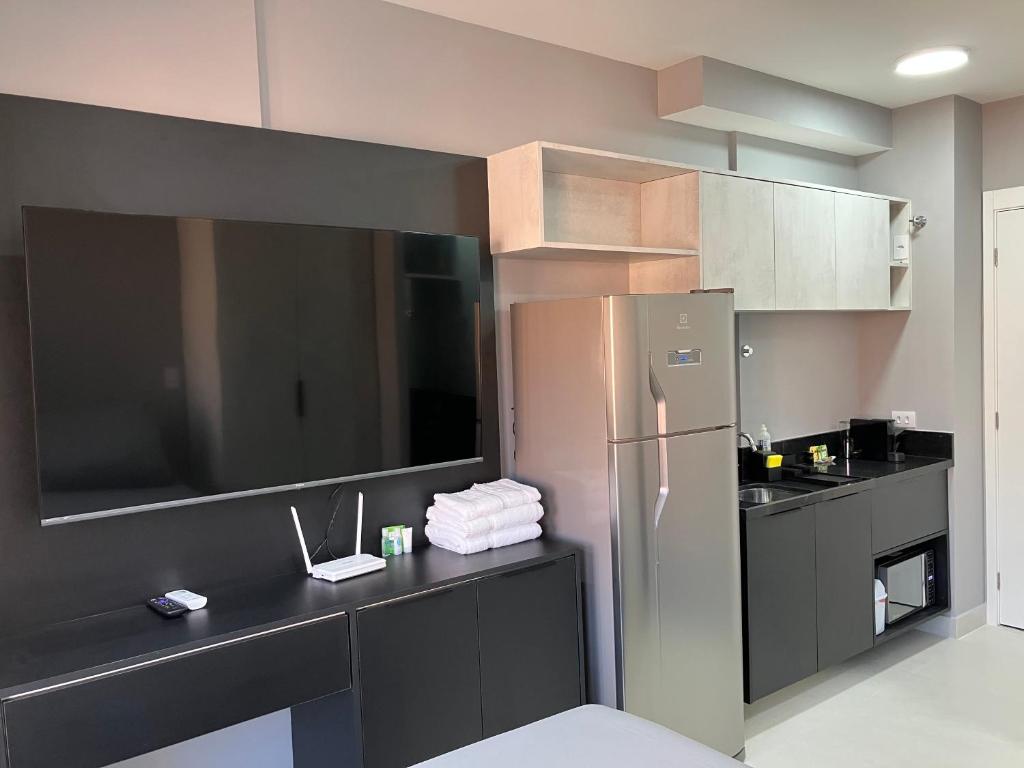 a kitchen with a stainless steel refrigerator and cabinets at Apto Brooklin ao lado do metro in Sao Paulo
