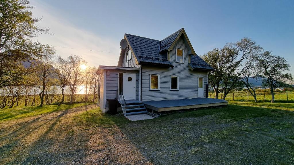 a small house with a porch on a field at Nappstraumen Seaview holiday home in Haug