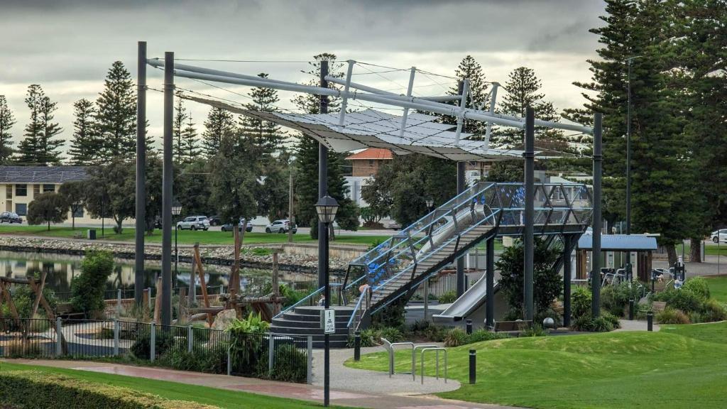 a slide in a park next to a river at Glenelg resort style beachside apartment in Glenelg