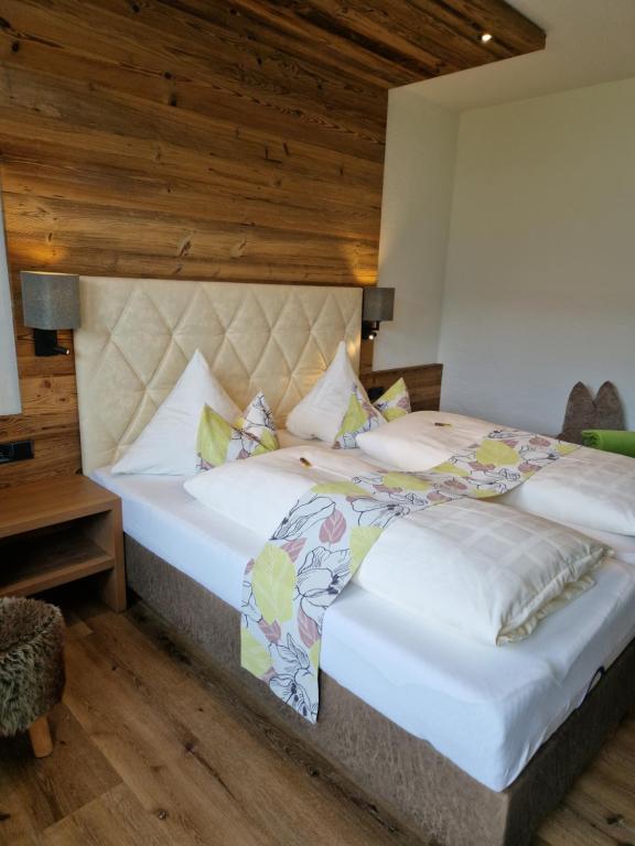 two beds in a room with wooden ceilings at Pension Claudia Zell am See in Zell am See