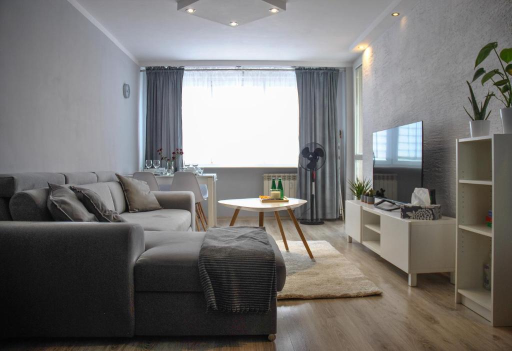 uma sala de estar com um sofá e uma mesa em Bohaterów Modlina Point by sleepwell em Nowy Dwór Mazowiecki