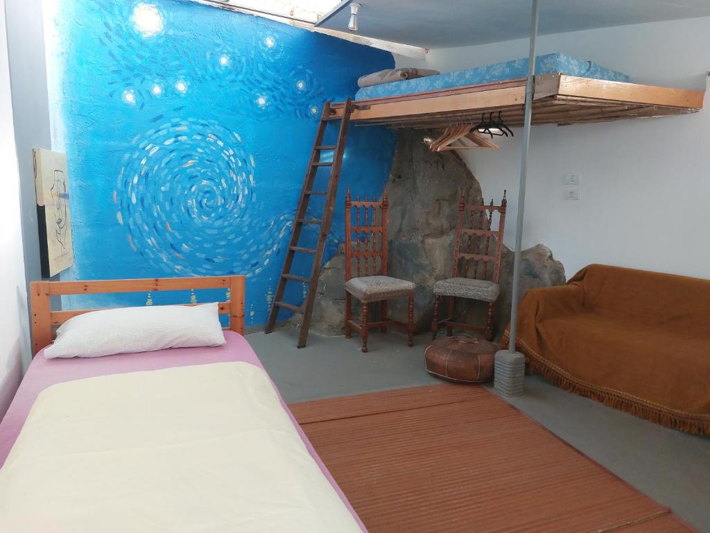 ein Schlafzimmer mit einem Etagenbett und einem Sofa in der Unterkunft Twin room in the greenhouse close to mountains and surf paradise in Tejina
