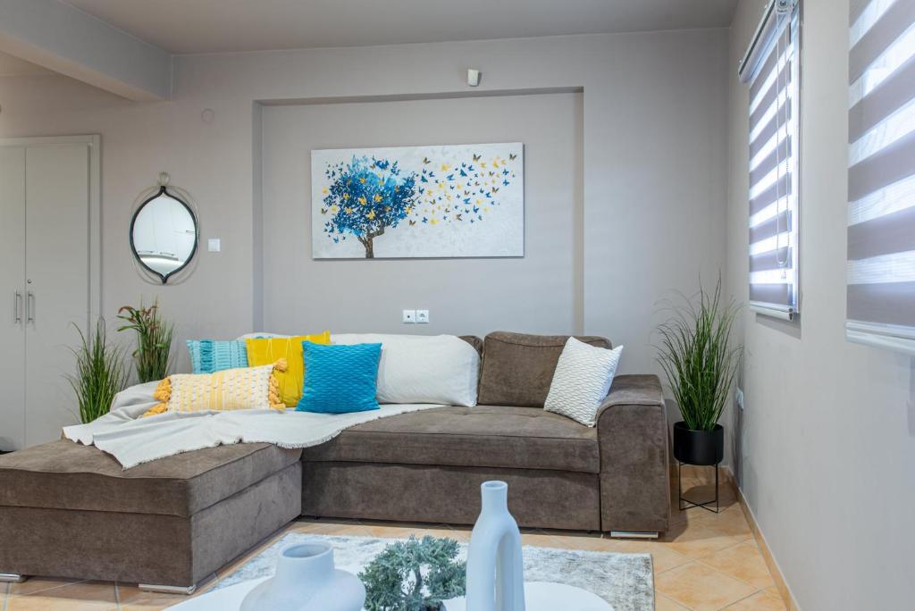 a living room with a brown couch with colorful pillows at Veria Panorama Luxury Suite with Garden 2 in Veria