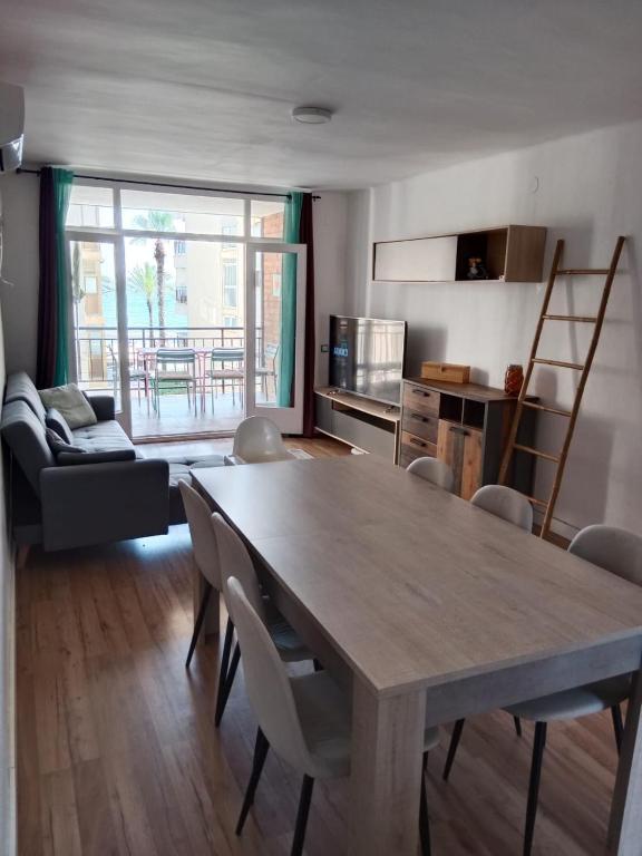 a living room with a wooden table and a kitchen at caracas in Salou