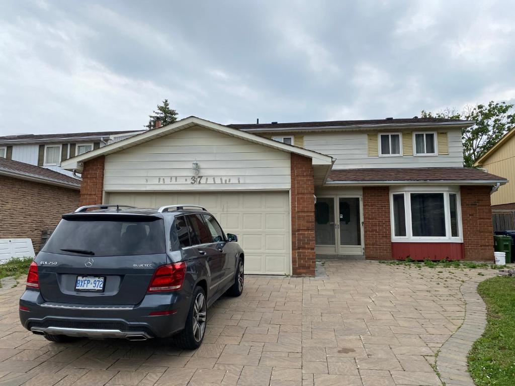 un SUV parcheggiato di fronte a una casa. di Homehouse a Toronto