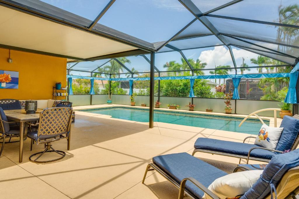 a swimming pool with chairs and a table at Pet-Friendly Cape Coral Vacation Rental with Lanai! in Cape Coral