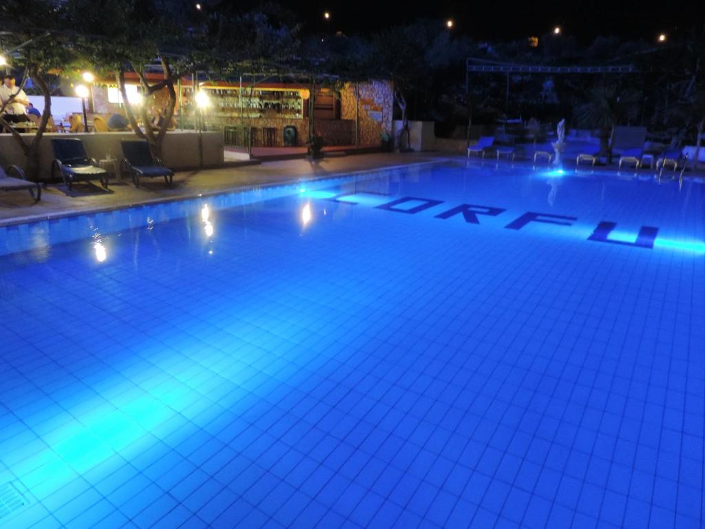a swimming pool lit up at night at Corfu Hotel in Ayia Napa