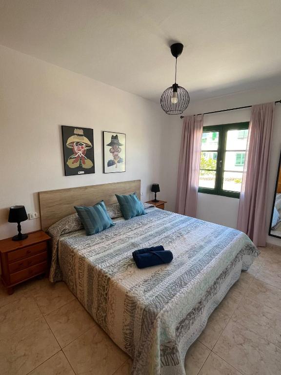 a bedroom with a large bed with blue pillows at Casa Noas in Playa Blanca