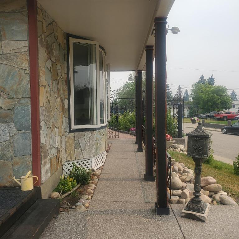 a stone house with a walkway next to a building at The Calgary Hub hostel style Home in Calgary