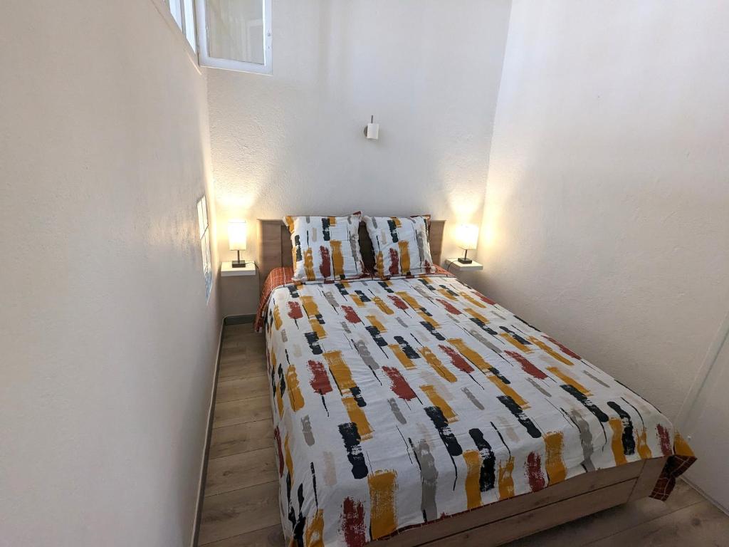 una camera con un letto con una trapunta sopra di Le Saint Jean Cosy et Confort a Villefranche-de-Conflent