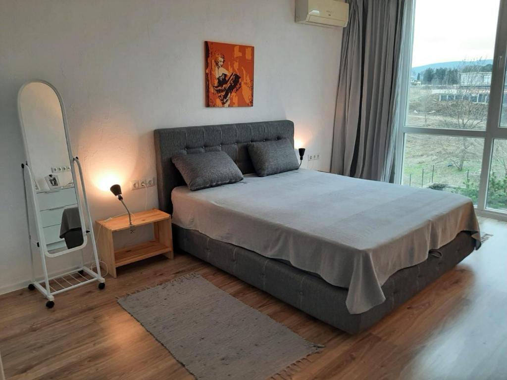 a bedroom with a large bed and a large window at Port Lozenets Apartment in Lozenets