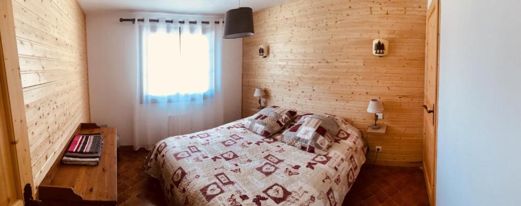 a bedroom with a bed with a wooden wall at El Chalet du Père Castor in Bolquere Pyrenees 2000