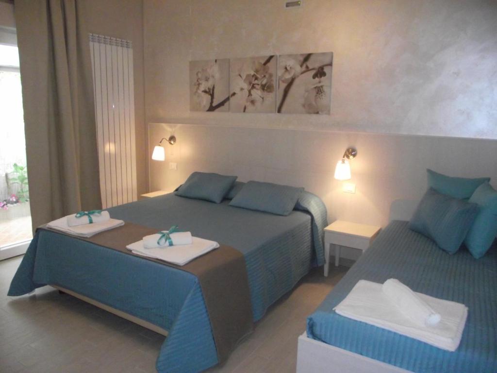 a bedroom with two beds with blue pillows at B&B Mediterranea Sea House in Montesilvano