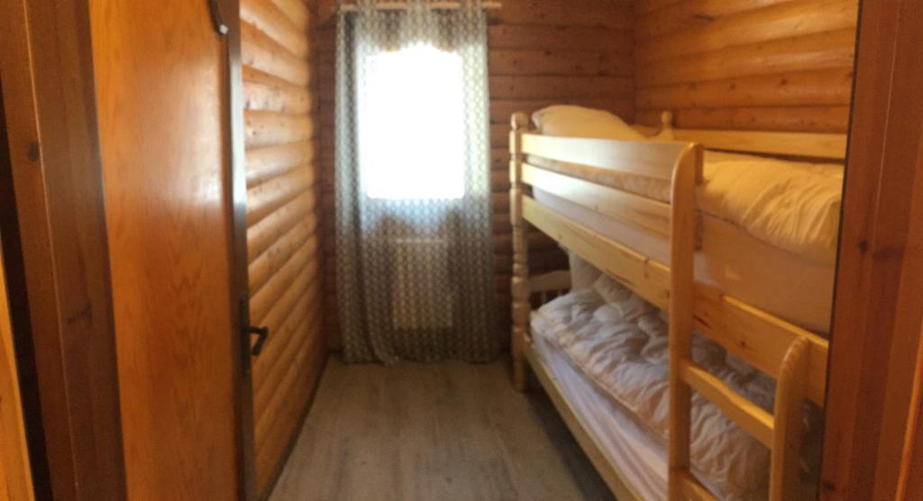 a room with two bunk beds and a window at El Chalet du Père Castor in Bolquere Pyrenees 2000