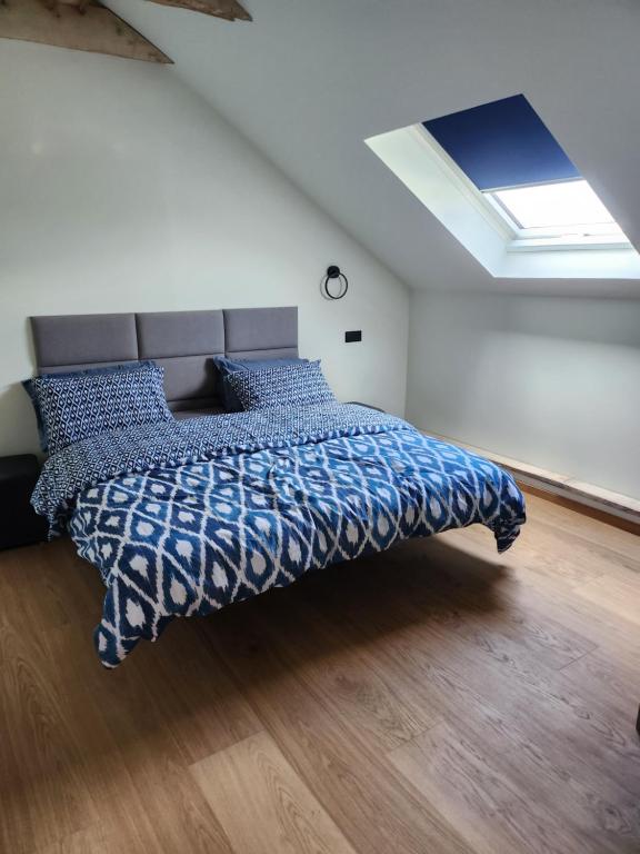 a bedroom with a bed with a blue comforter at Blue Door Apartment Loft in Augustów