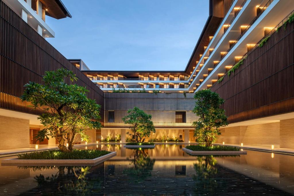 una vista exterior de un edificio con árboles y luces en The Taikang Sanya, a Tribute Portfolio Resort en Sanya