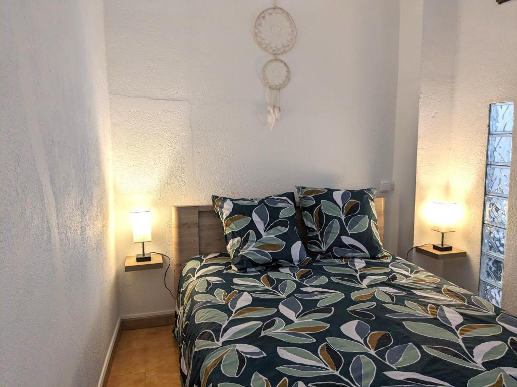 una camera da letto con un letto con due lampade sopra di Appartement Saint Jean 2 Cosy et Confort a Villefranche-de-Conflent