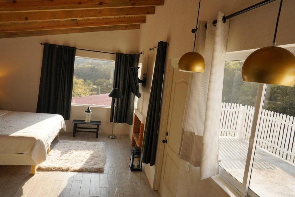 1 dormitorio con cama y ventana grande en Cabaña El Encino III en Real del Monte, en Mineral del Monte