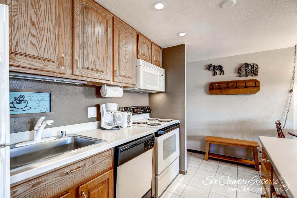 a kitchen with a sink and a stove top oven at RECENTLY UPDATED Ski In & Out Condo with Heated Garage Parking and VIEWS! TE303 in Breckenridge
