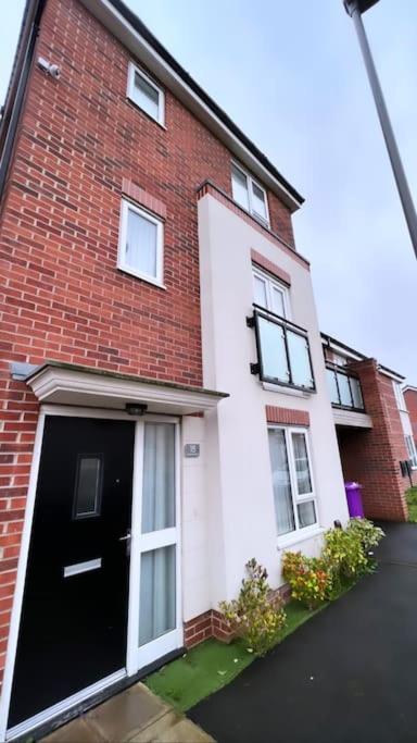 una casa de ladrillo rojo con una puerta negra en 3 stories, 5 BR House in Prime Location with balcony and shared Garden, en Liverpool