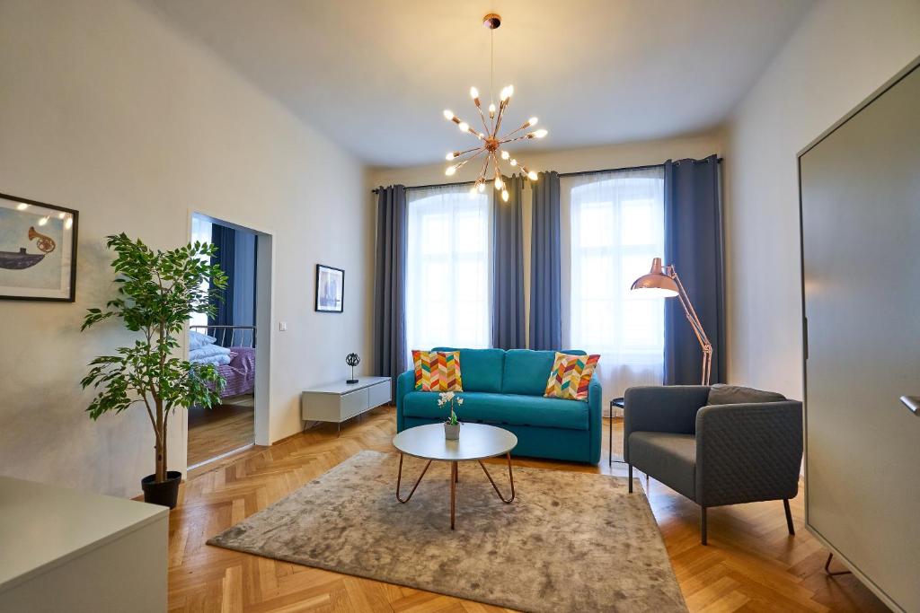ein Wohnzimmer mit einem blauen Sofa und einem Tisch in der Unterkunft Fancy Home For 5 With Self-Check-In At Spittelberg in Wien