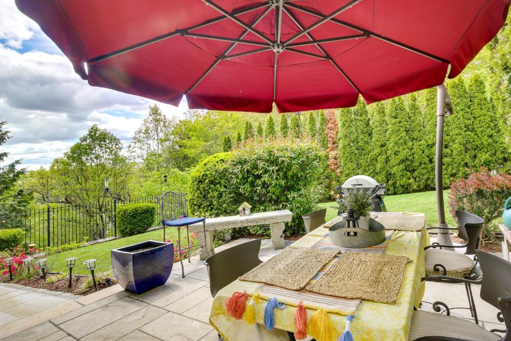 - une table avec un parasol rouge sur la terrasse dans l'établissement Putnam Valley Vacation Rental Patio and Lake Views!, à Putnam Valley