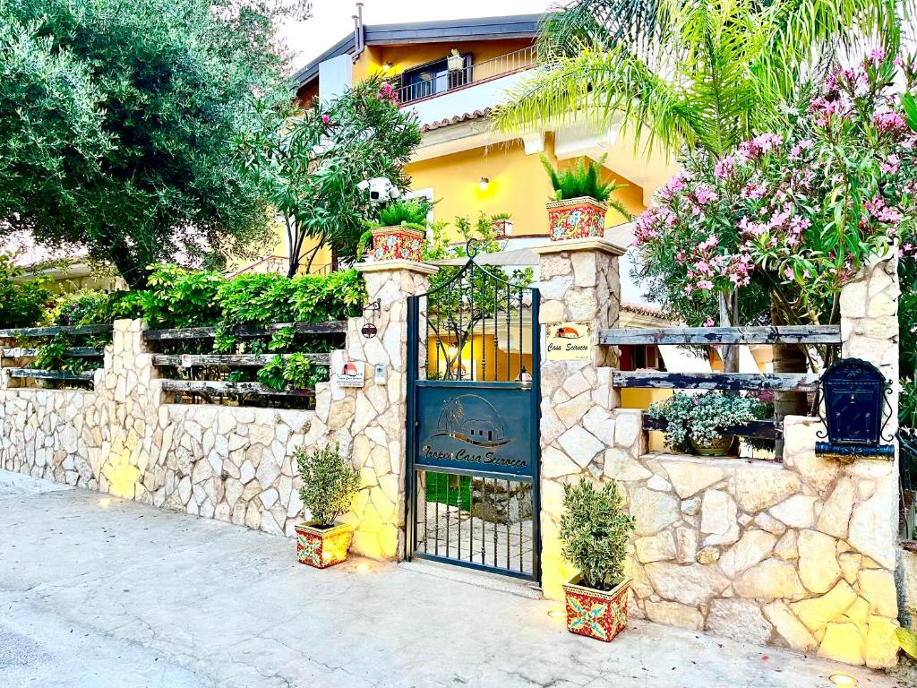 a stone wall with a gate with potted plants on it at Tropea Casa Scirocco in Tropea