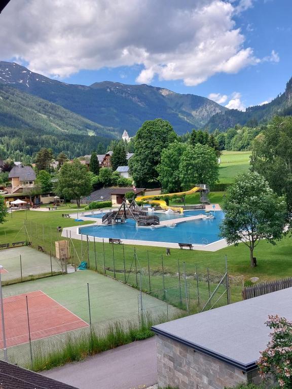 Blick auf einen Tennisplatz mit Pool in der Unterkunft Apartment Ledermoos in Mauterndorf