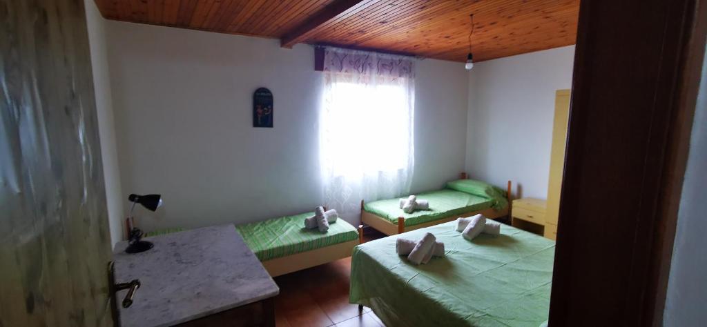 um pequeno quarto com 2 camas e uma janela em Casa vacanze CALU' em Cittadella del Capo