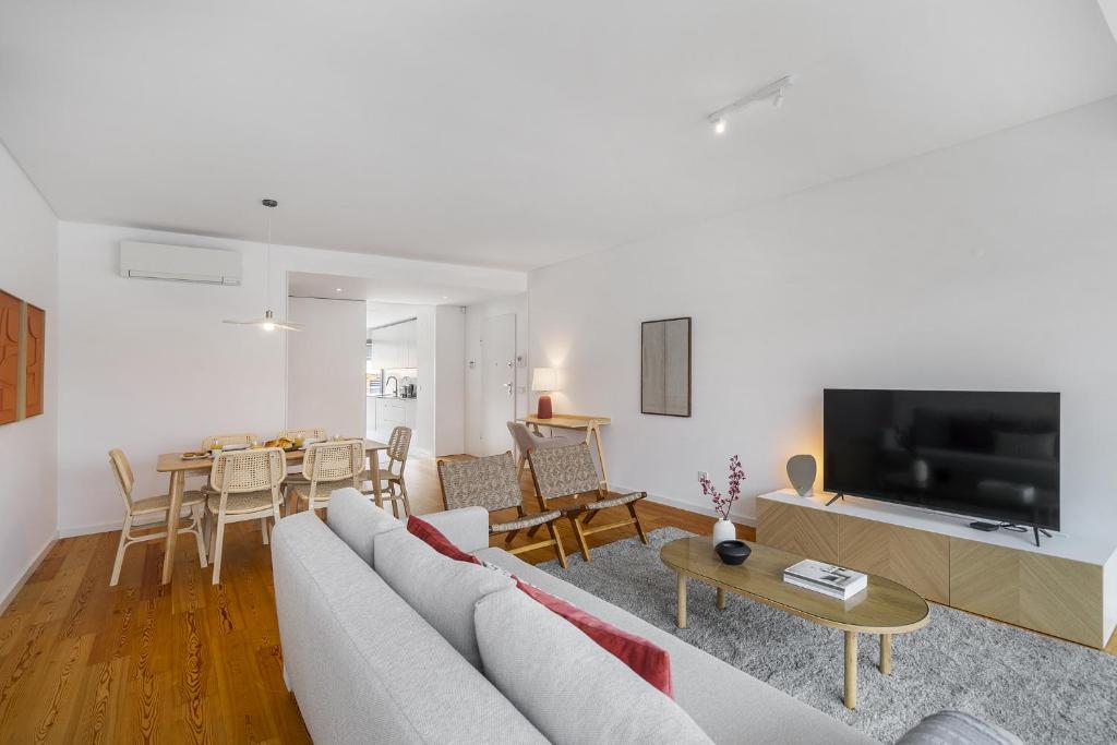 a living room with a couch and a tv and a table at WHome Urban Retreat w/Parking, Elevator & AC by Benfica Stadium in Lisbon