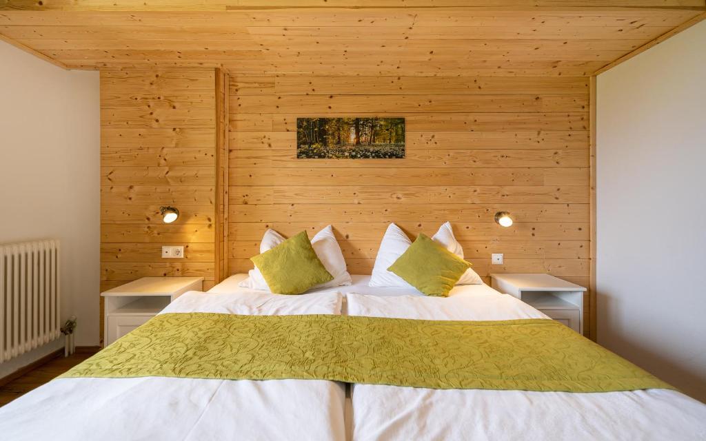 Schlafzimmer mit einem großen Bett und Holzwänden in der Unterkunft Pension Hofweyer in Ramsau am Dachstein