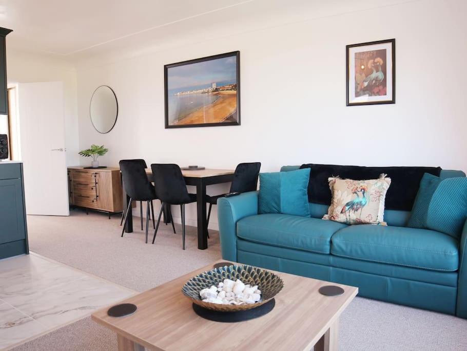 sala de estar con sofá azul y mesa en Ocean View apartment, beautiful sea views, en Kent