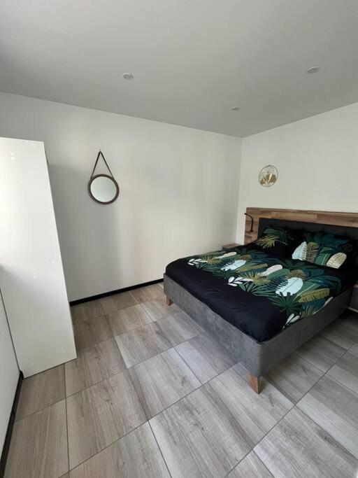 a bedroom with a bed and a wooden floor at Maison proche Le Pal in Neuilly-le-Réal