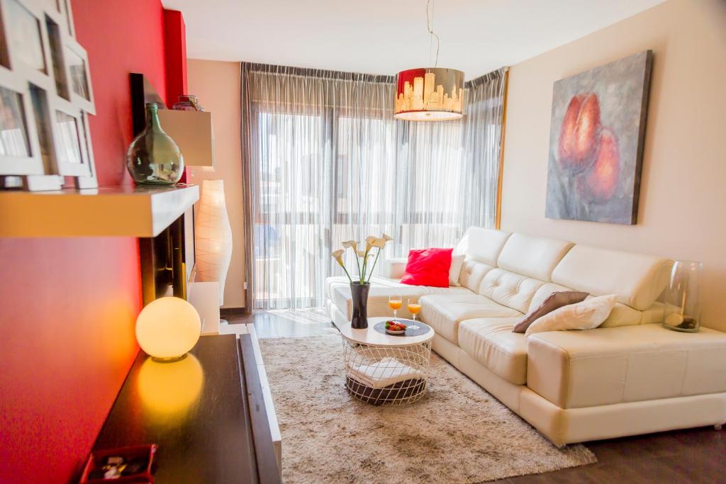 uma sala de estar com um sofá branco e uma parede vermelha em Mirador Islas de Arosa em Ribeira