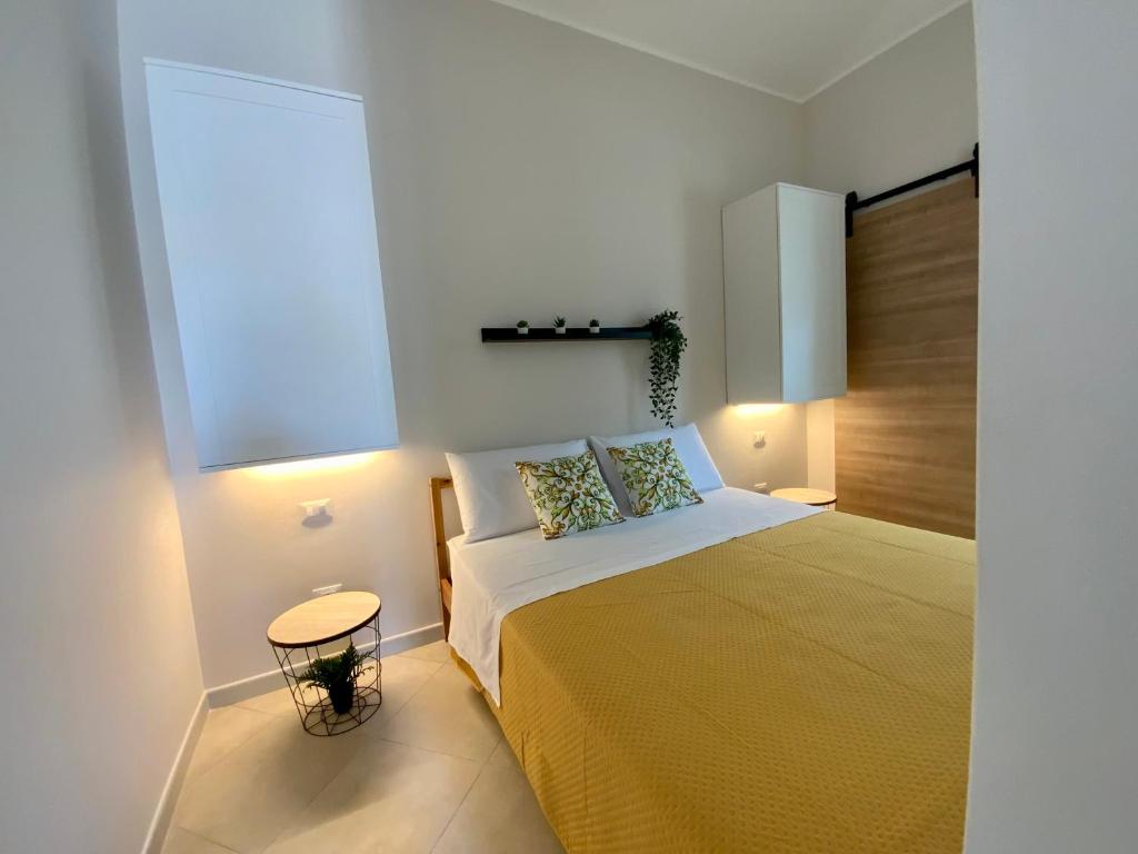una camera da letto con un grande letto con una coperta gialla di “Bedda Mattri” dimora siciliana ad Avola