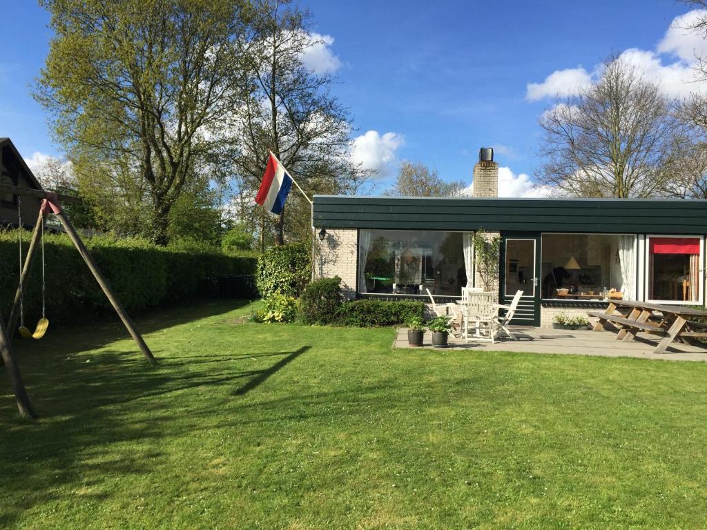 a house with a flag in the yard at Kreek Krak in Arnemuiden