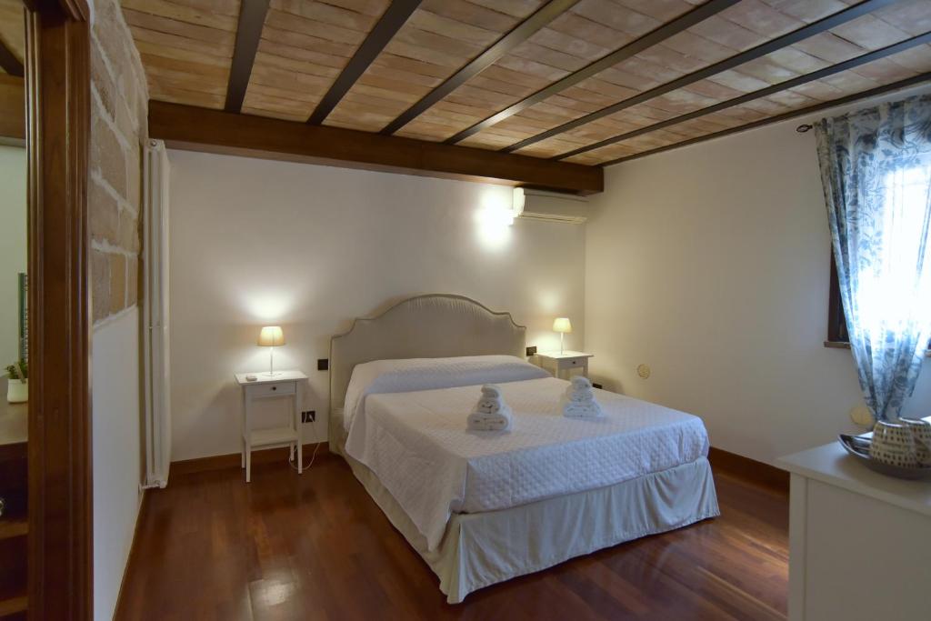 ein Schlafzimmer mit einem weißen Bett und einer Holzdecke in der Unterkunft BIBI'S HOUSE in Terrasini